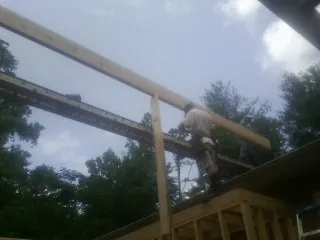 Carpenter setting a ridge beam over a new addition frame — Ice Dam Removal by Roofing Brothers in Mulino
