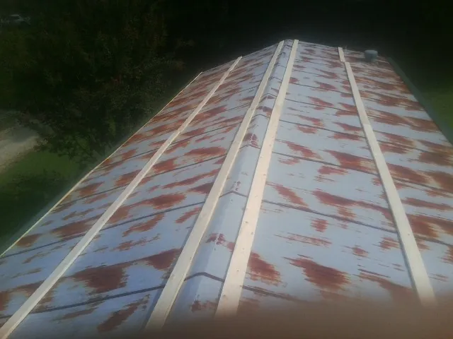 Rusted metal roof panels with new wood purlins before replacement — Storm Damage Roof Repair in Mulino by Roofing Brothers